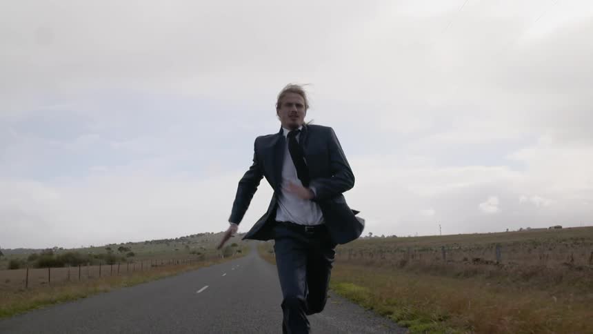 Man running down the road in a tuxedo