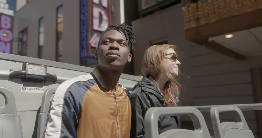 Two people sit on the tour bus together as it travels