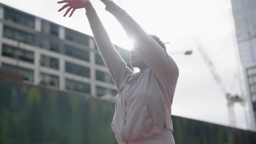 A woman shoots the basketball in the park
