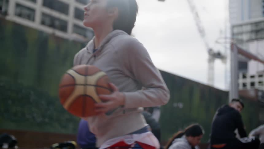 A woman dribbles the basketball on the court