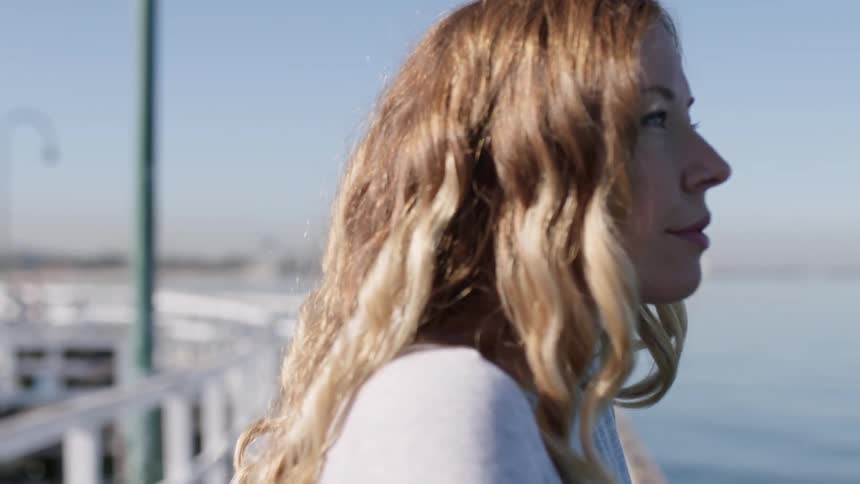A woman looks out over the water on a sunny day
