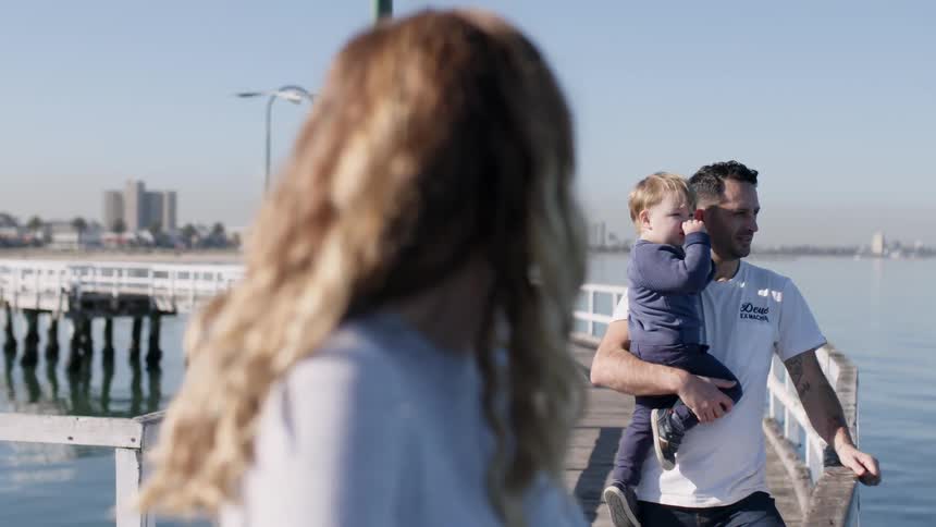Couple and toddler standing on a pier