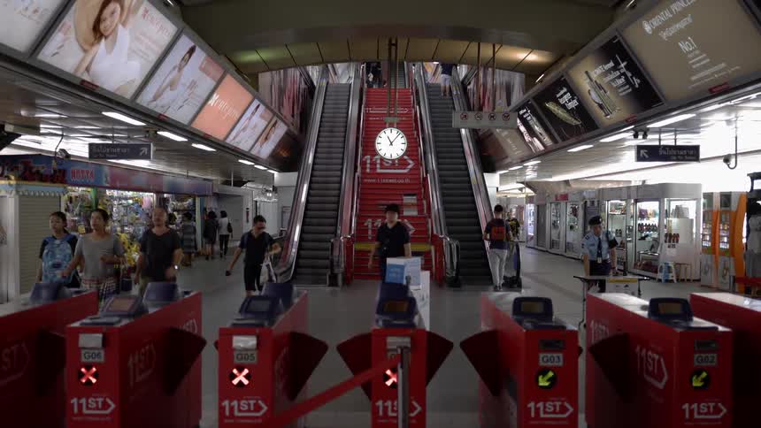 People walk through gates in a train station