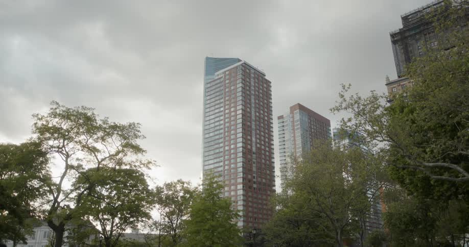 A tall building reaches up into the cloudy sky