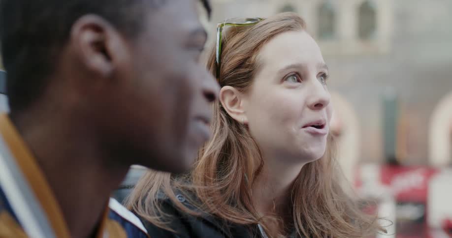 A woman talks with a man outside in the city
