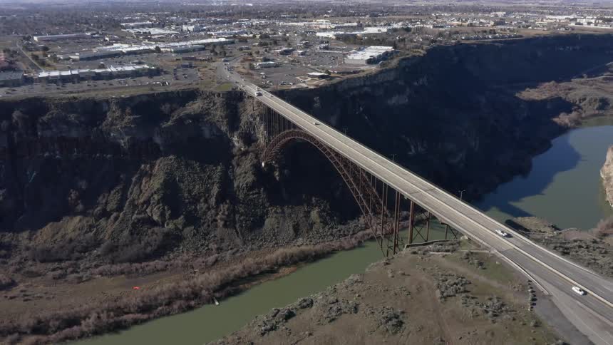 The bridge gaps the river with many cars traveling