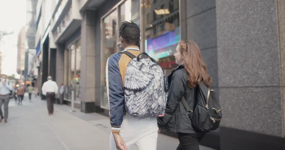 A couple walk down the city block together