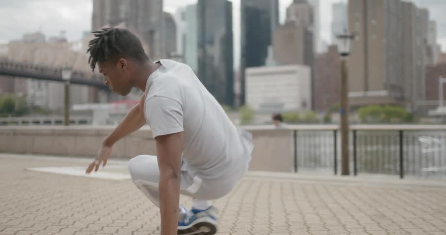 Man near city river break dances