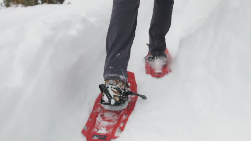 A person treks through the snow with snowshoes