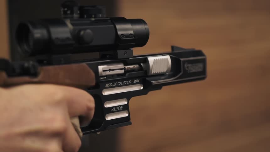 A person fires off a handgun with a large scope
