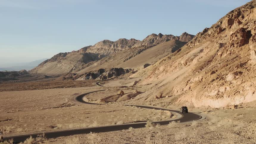 SUV driving down winding desert road