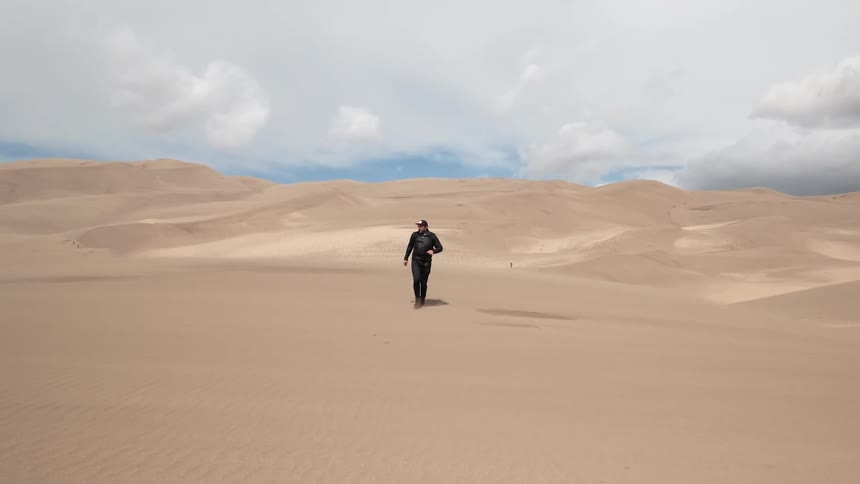 Person running through sand dunes