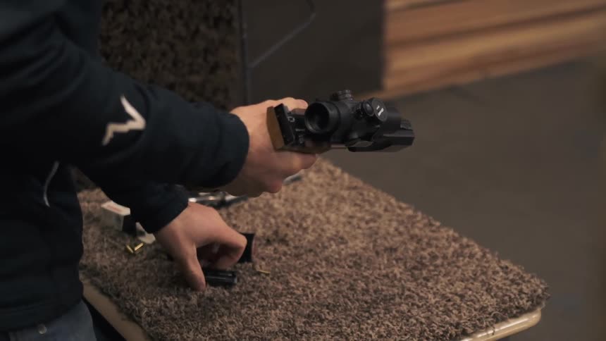 A man loads up his gun with a clip