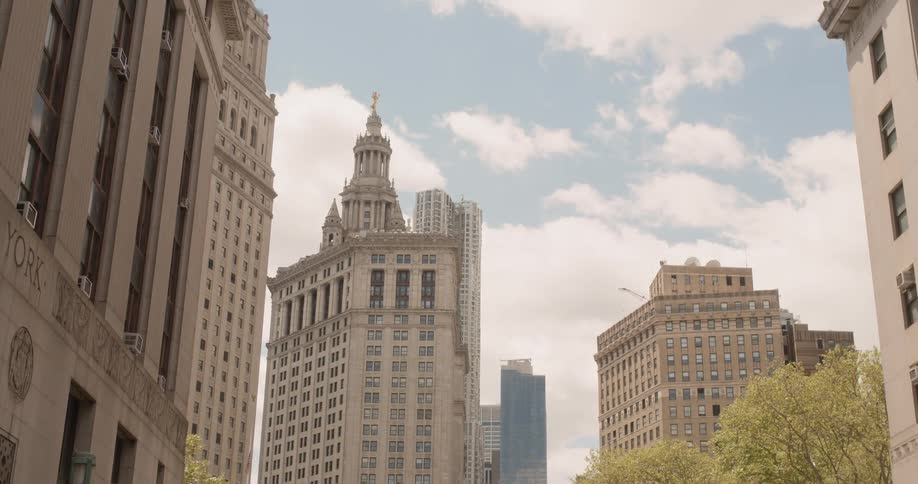 Clouds float over tall city buildings