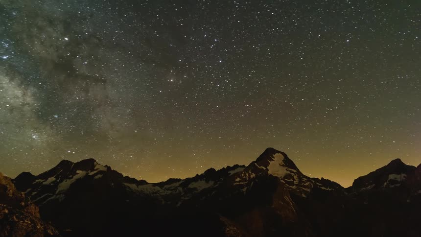 Night comes to snow capped mountains