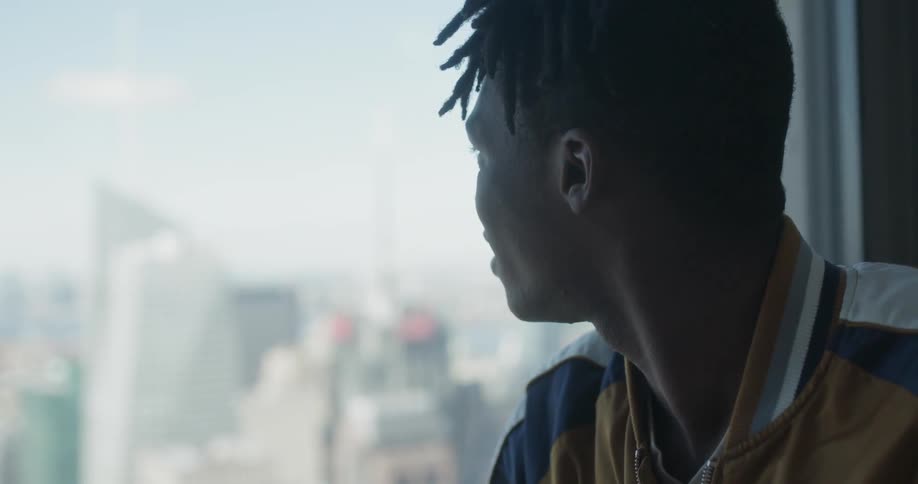 Man looks out window, smiles and talks