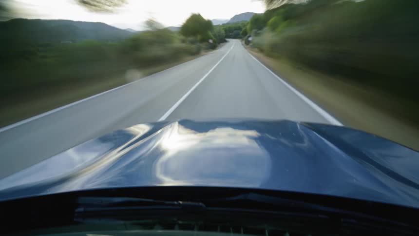 Car speeds quickly down a country road