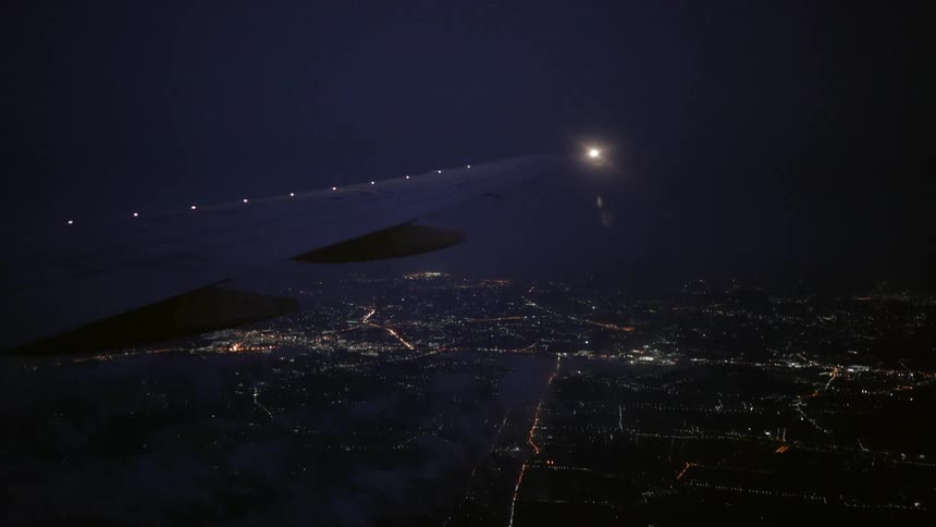 The plane is flying high in the sky at night