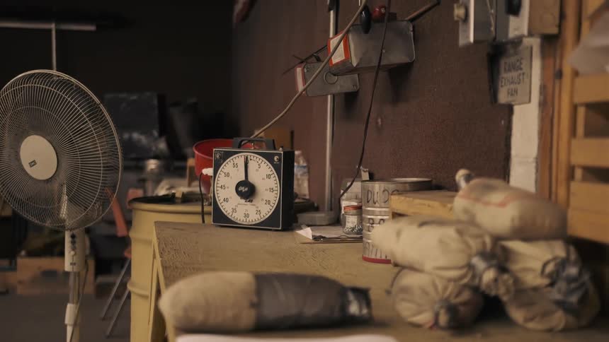 The bench is covered with tools and a clock