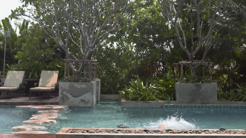 Child swims in a pool on a sunny day