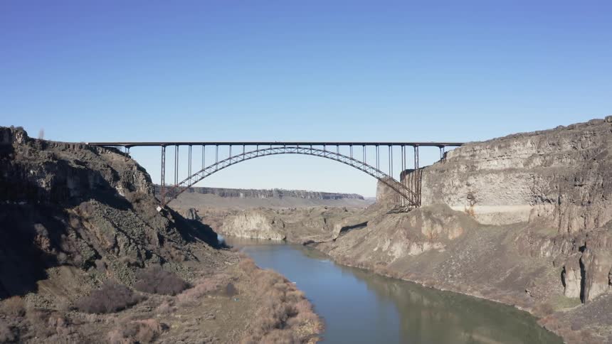 The large bridge covers the river on a sunny day