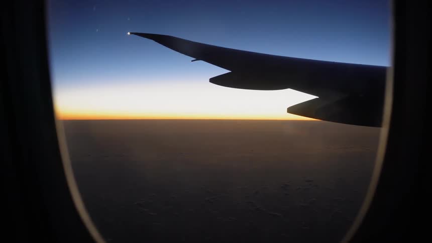 A plane flies above the clouds
