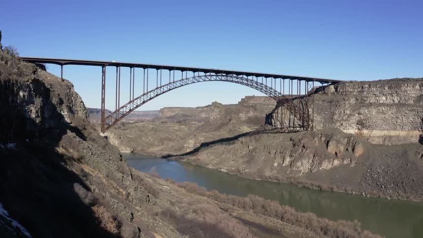 The vehicle travels over the bridge over the river