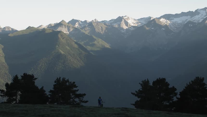 Person stands looking at a large mountain range