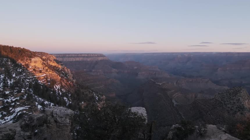 The sun shines on the large layered canyon