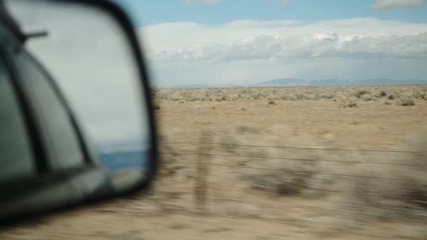 The vehicle is driving past the long fields