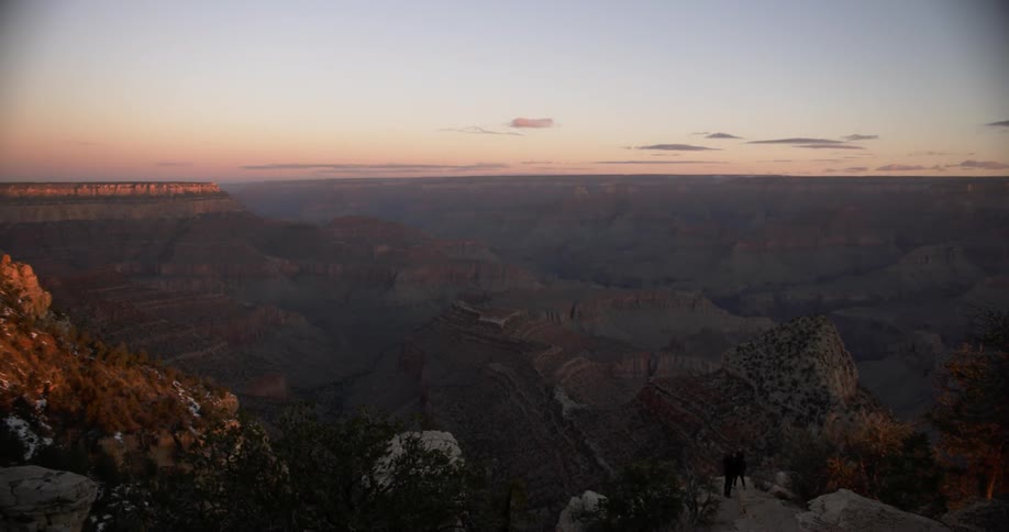 People walk to the cliff edge of the canyon