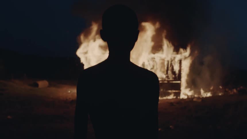 Boy watches a burning house