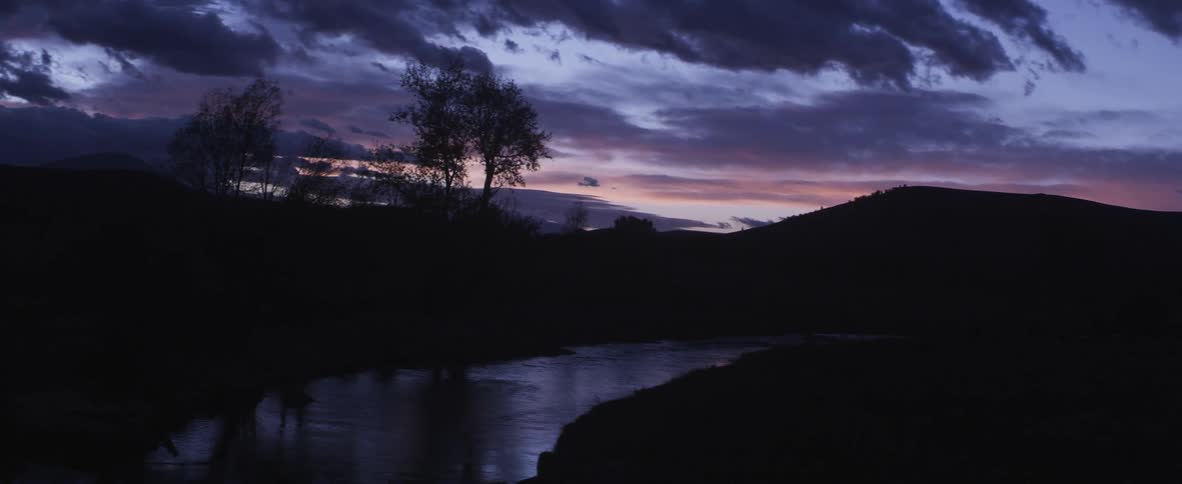 A river bend at sunset on a cloudy evening