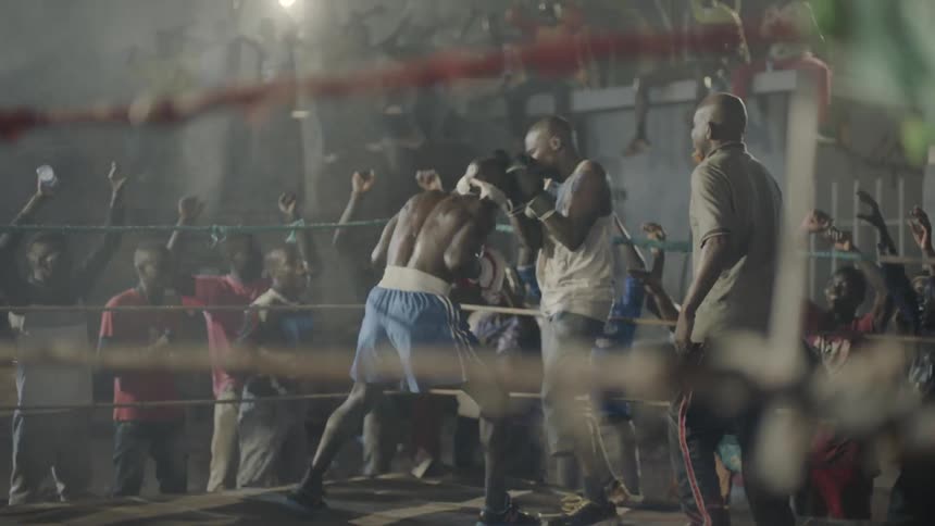 A crowd cheers at a boxing match