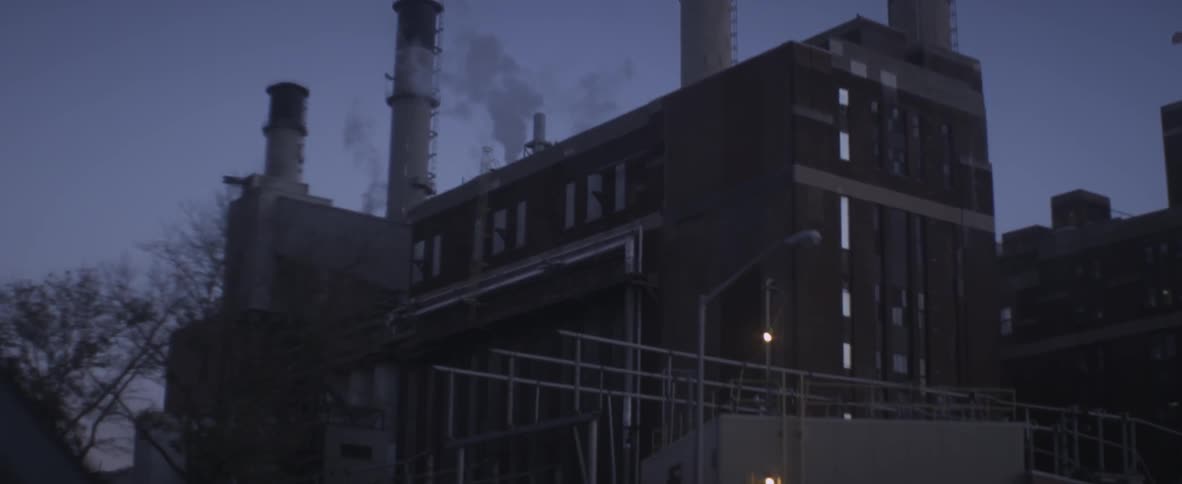 Driving past a factory with large smokestacks