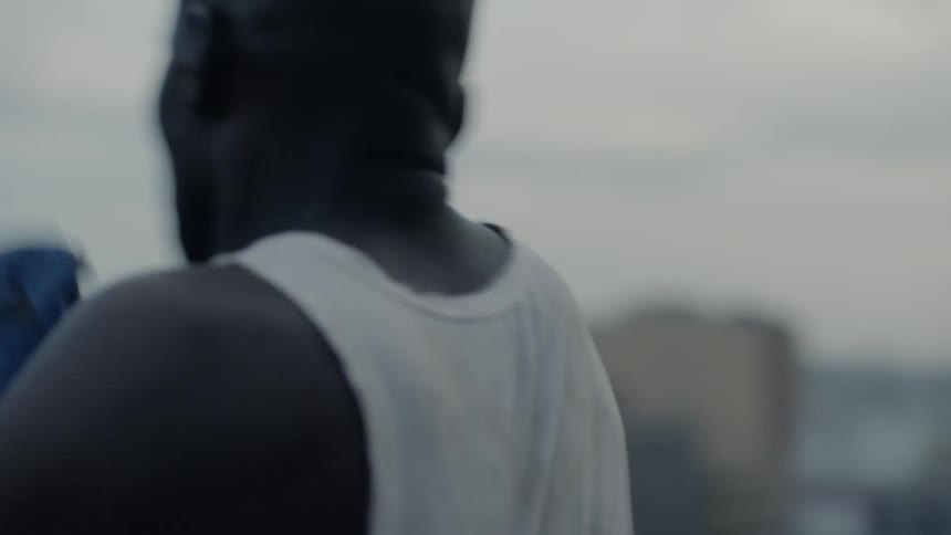 A boxer punches the air in a city at sunset