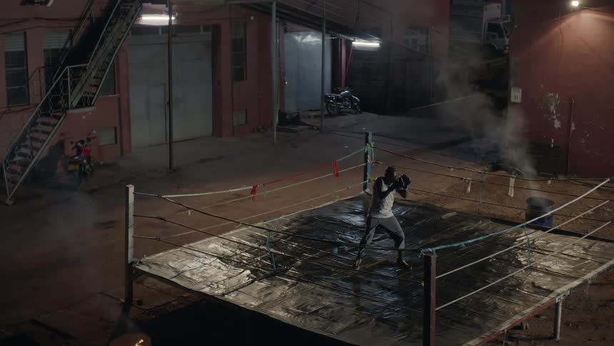 Man boxes alone in an outdoor boxing ring