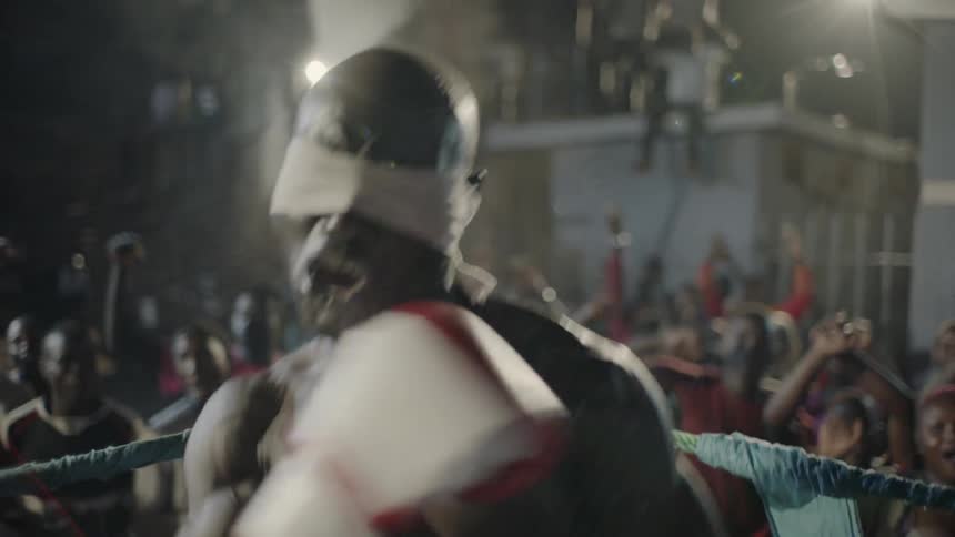 A crowd cheers for a boxer in a boxing ring