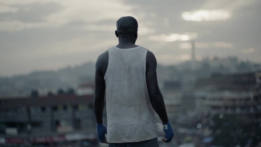 Man stands on a building rooftop at sunset