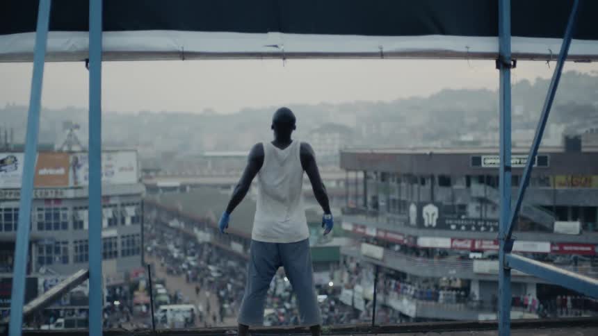 Man standing on rooftop viewing a city during the day