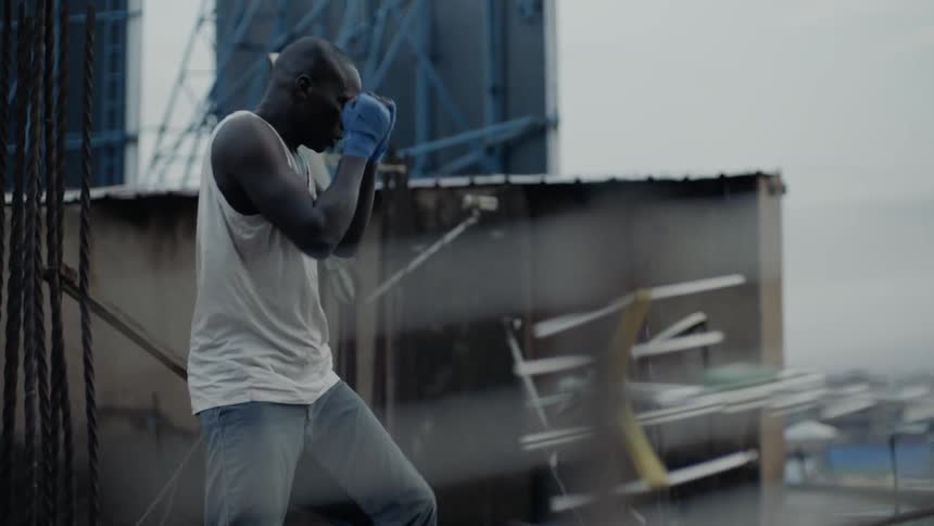 Man practices punching while standing on a rooftop
