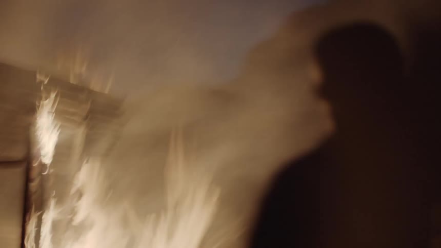 Man watches a burning house
