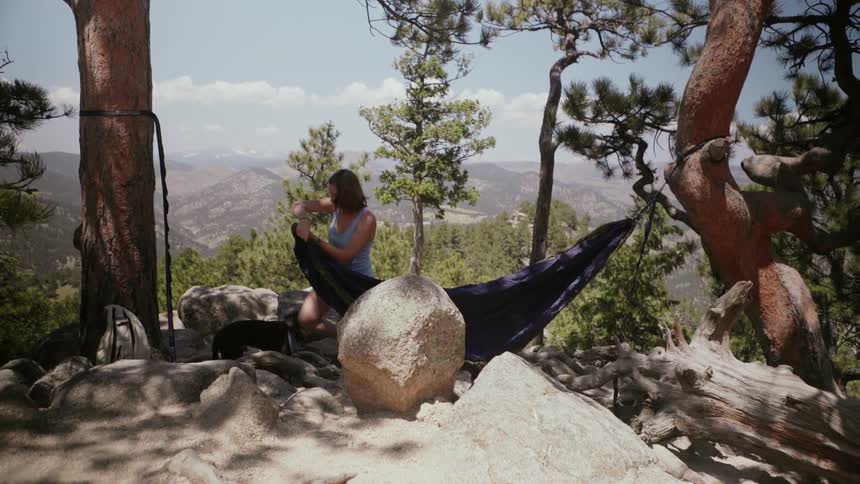 Woman ties hammock to trees