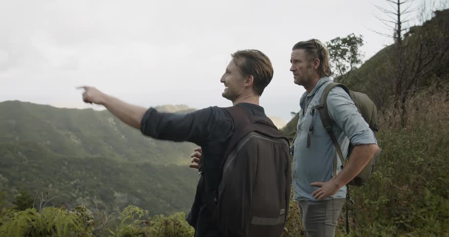 Two men stand on a hilltop sightseeing