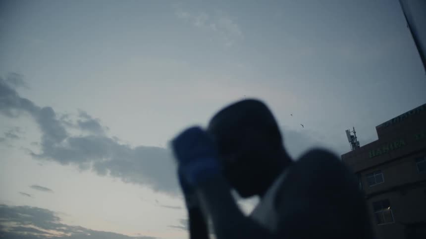 Man practices punching outside at sunset