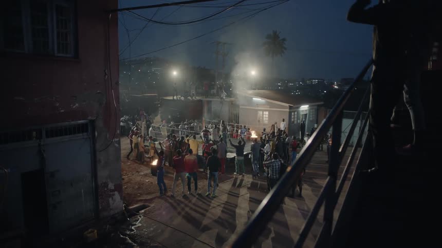 People dance near a bonfire