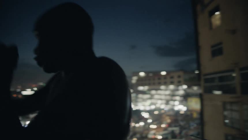 A boxer punches the air on a building rooftop