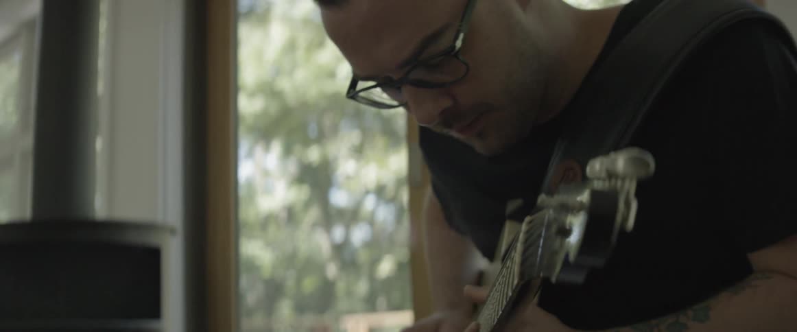 A man plays guitar indoors