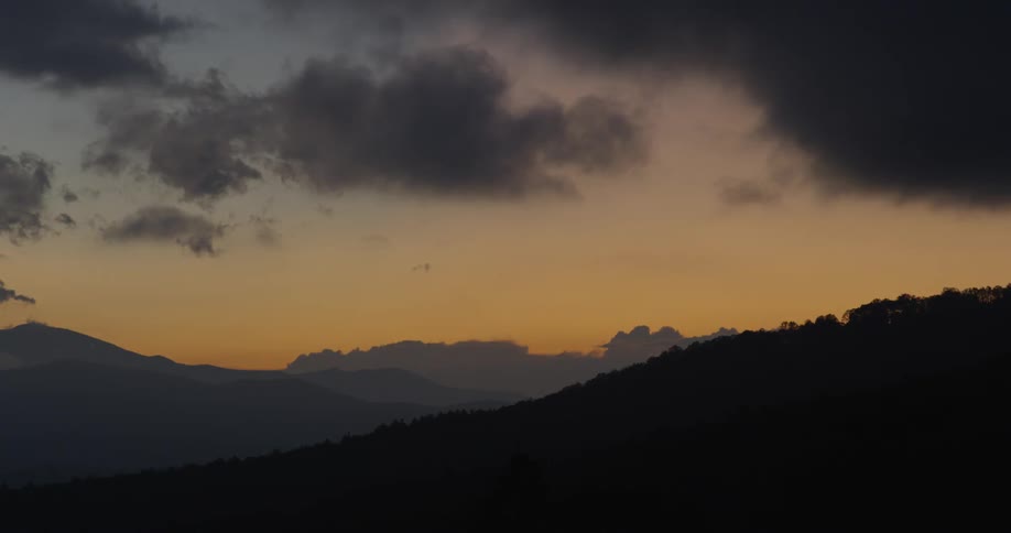 Clouds moving over the mountains at sunset