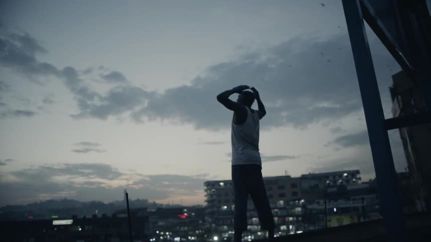 Man standing on rooftop viewing a cityscape